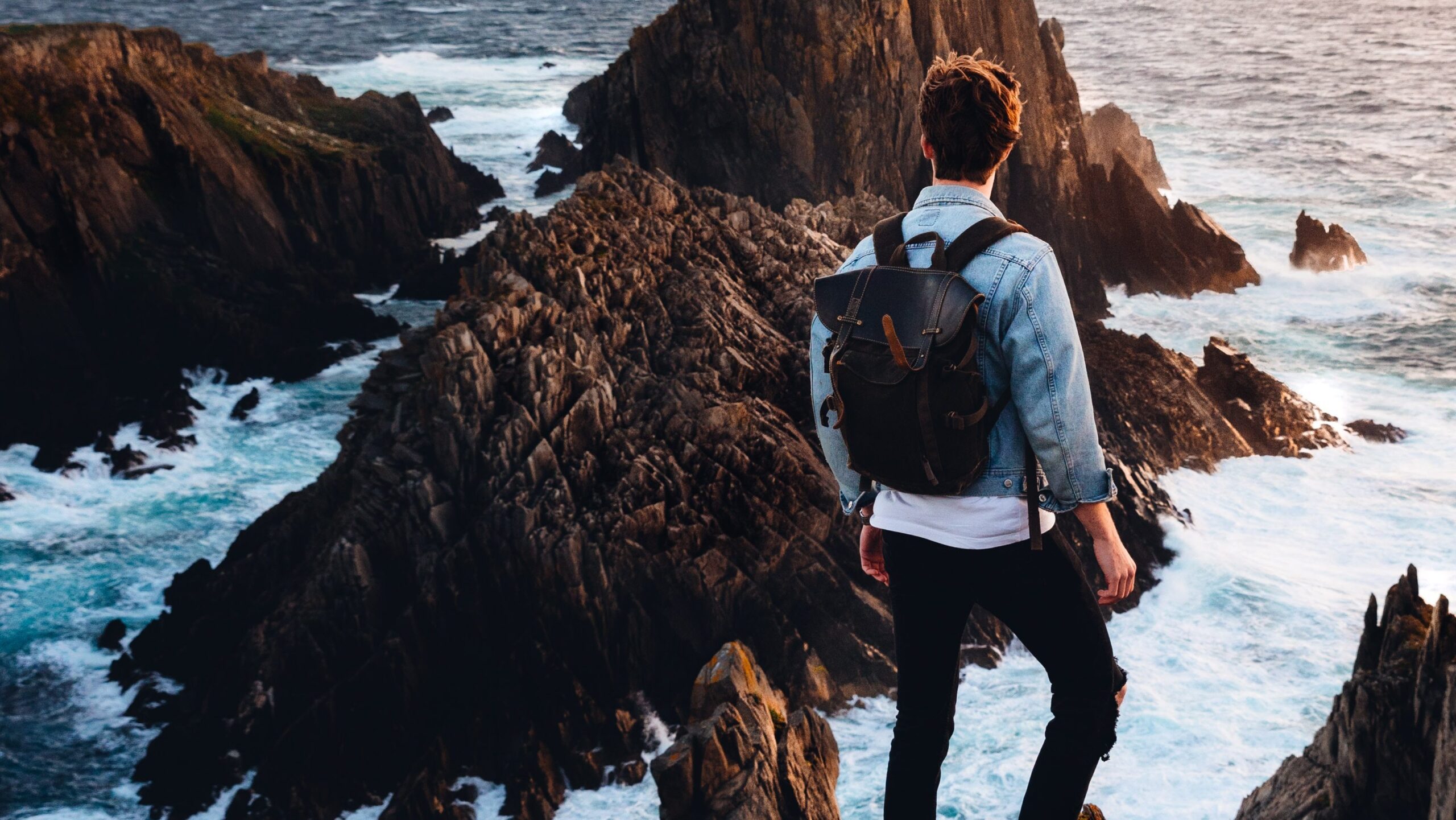 Homme sur un rocher observant l'horizon